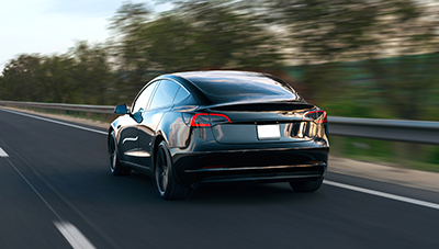 Moving black car on road